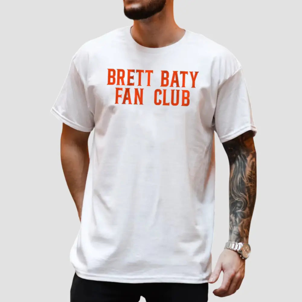 White t-shirt featuring 'Brett Baty Fan Club' in bold orange text, perfect for New York Mets fans.